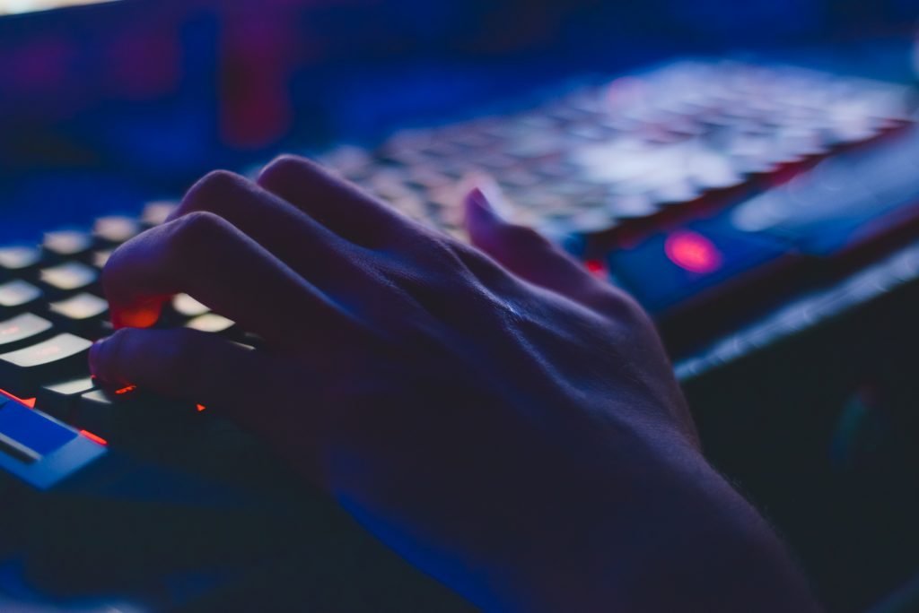 a nightly low-light picture of a hand on top of a keyboard